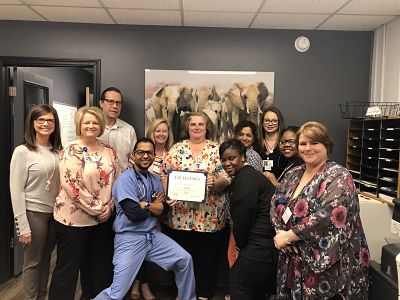 This is a picture of some of the staff with Patricia Hill while she receives the employee of the month