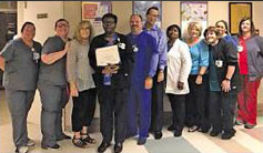 This is a picture of some of the staff with Earnestine Jefferson while she receives an Employee of the month Award.