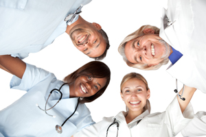 This is a picture of doctors and nurses huddling in a circle smiling